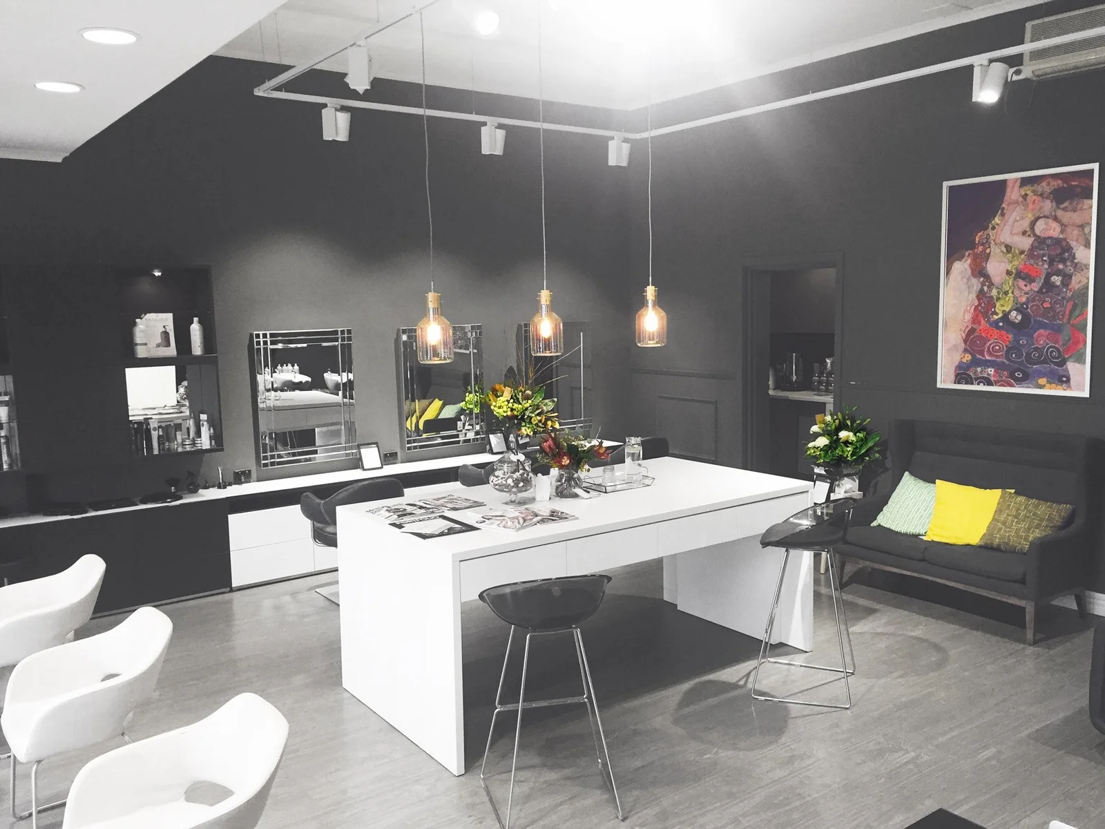 Salon August interior — dark charcoal walls, pendant lights, contemporary design